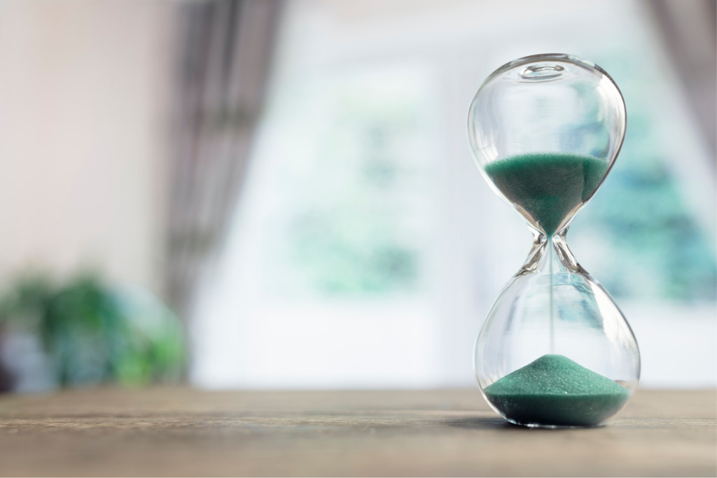 istock hourglass-time-passing-in-room-by-window-picture-id1133384135