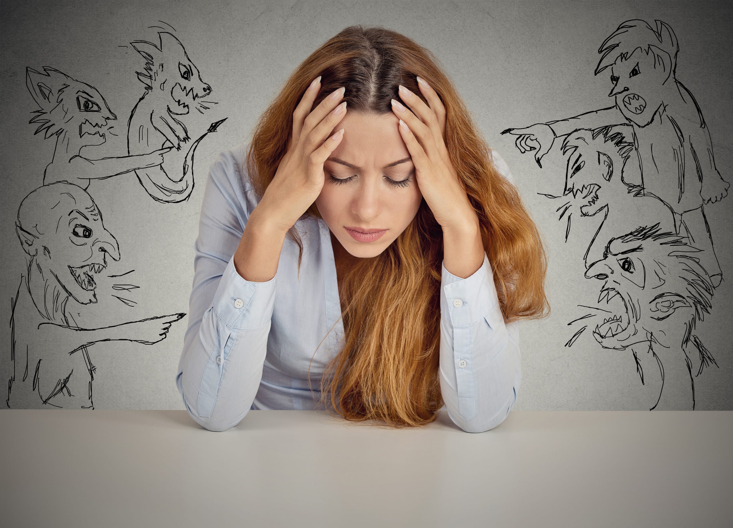 Desperate young businesswoman sitting at desk in her office