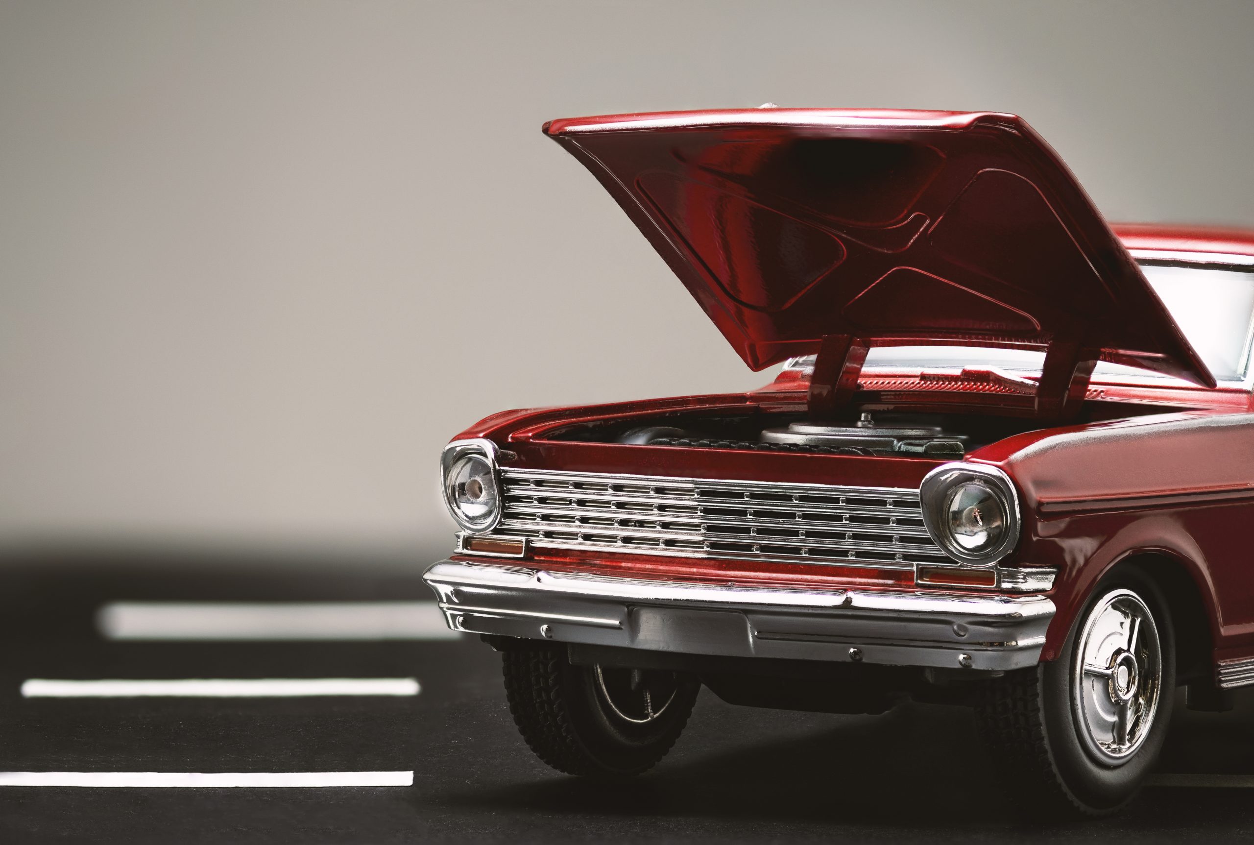 Front view of a Red classic automobile with open hood.